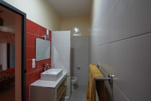 Une petite salle de bain avec un lavabo blanc, un miroir et un porte-serviettes.