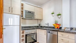 A modern kitchen with a refrigerator, oven, microwave, and dishwasher.