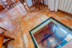 A tiled floor with a glass table in the center.