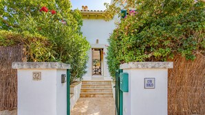 A pathway leading to a building with a white exterior, a green door, and a sign reading "C'n Bolis". - Can Sivinar by dracmallorca (Santanyi)
