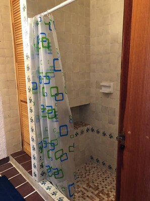 A shower area with a patterned shower curtain, tiled walls, and a wooden door. - Villa 42 La Rinconada, Tequisquiapan (Tequisquiapan)