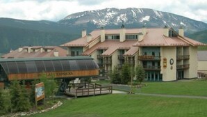 Un hotel con vistas a la montaña, que presenta un gran letrero de 'Lana Express' y un espacio exterior cubierto.