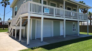 Ein zweistöckiges Haus mit Balkon, Garage und einer Treppe, die zum oberen Stock führt.