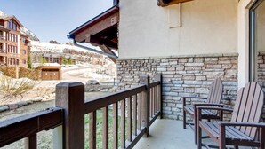 A balcony with wooden chairs and a stone wall. - Deluxe, Classic Mountain Condo | Near Chairlifts (Crested Butte)