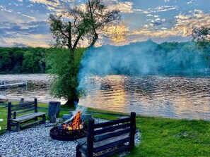 Une vue sur le lac, avec un foyer et des bancs en bois.