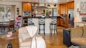 A spacious living room with a beige sofa, a coffee table, and a dining area with a table and chairs.