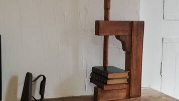A wooden desk with a vintage-style press tool and a stack of books.