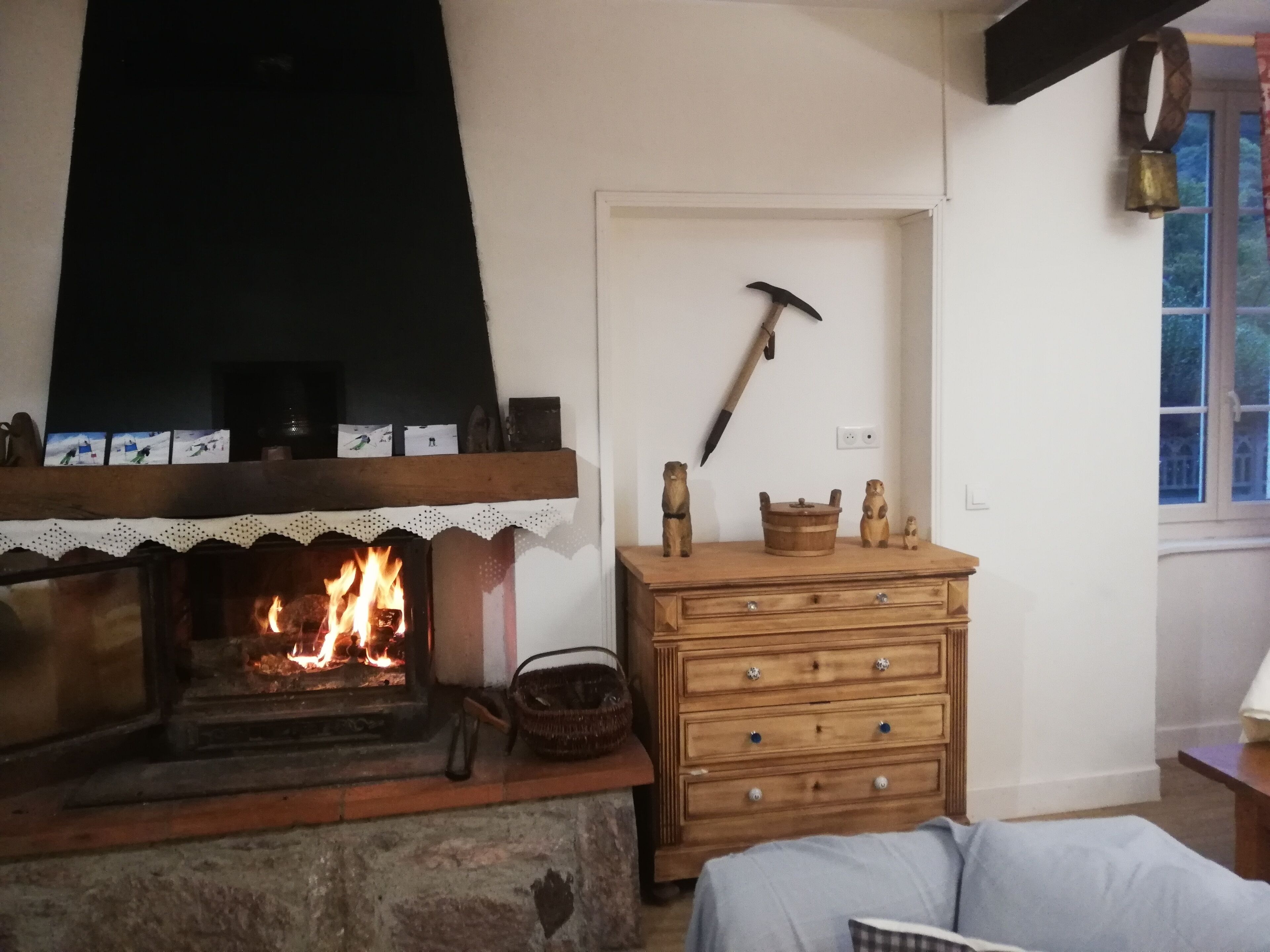 Una habitación acogedora con chimenea, cómoda de madera y decoración rústica que incluye un pico y figuras de osos.
