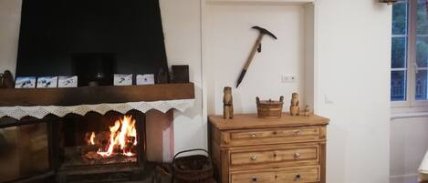 Una habitación acogedora con chimenea, cómoda de madera y decoración rústica que incluye un pico y figuras de osos.