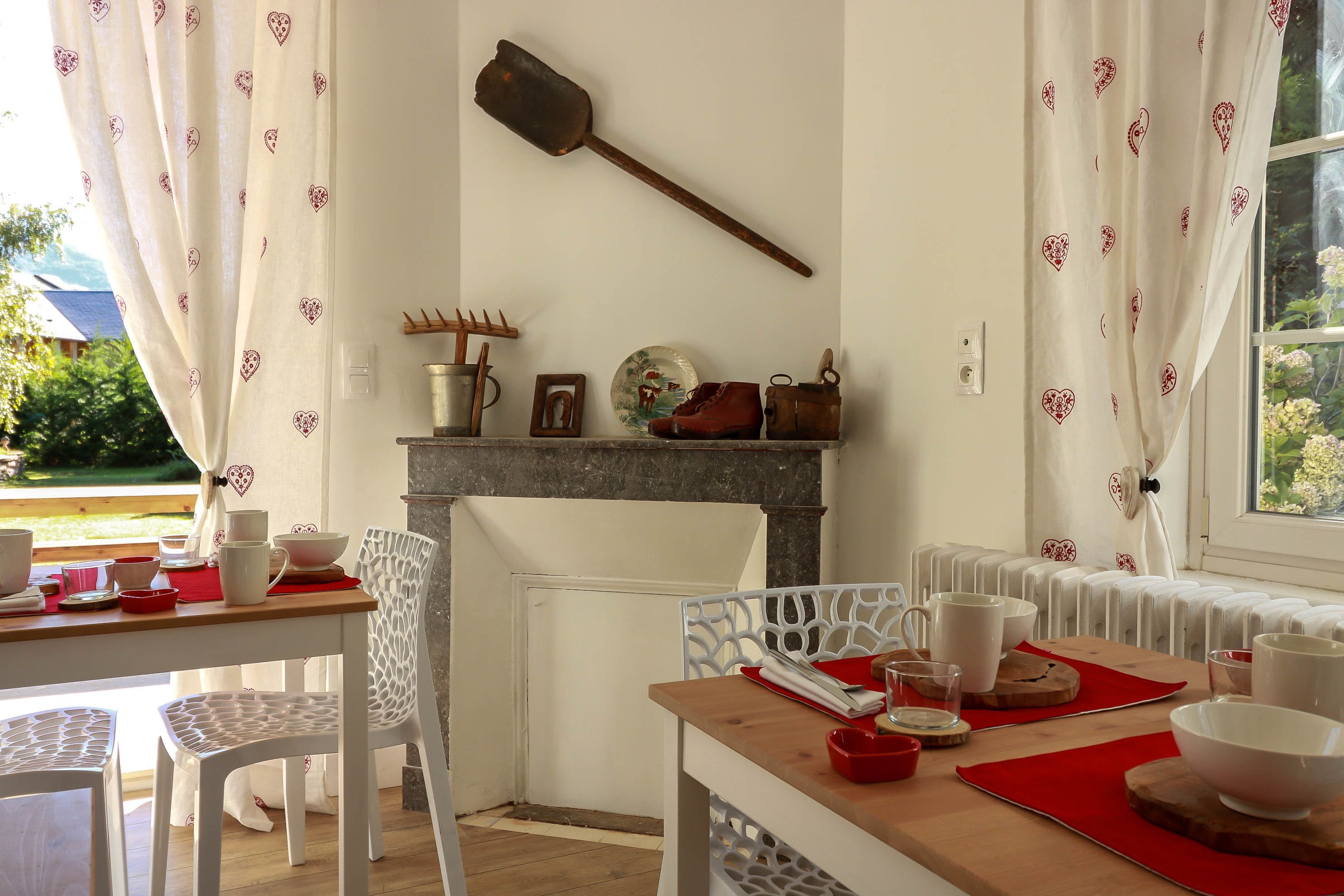Uma sala de jantar com uma mesa de madeira, cadeiras brancas e uma lareira.