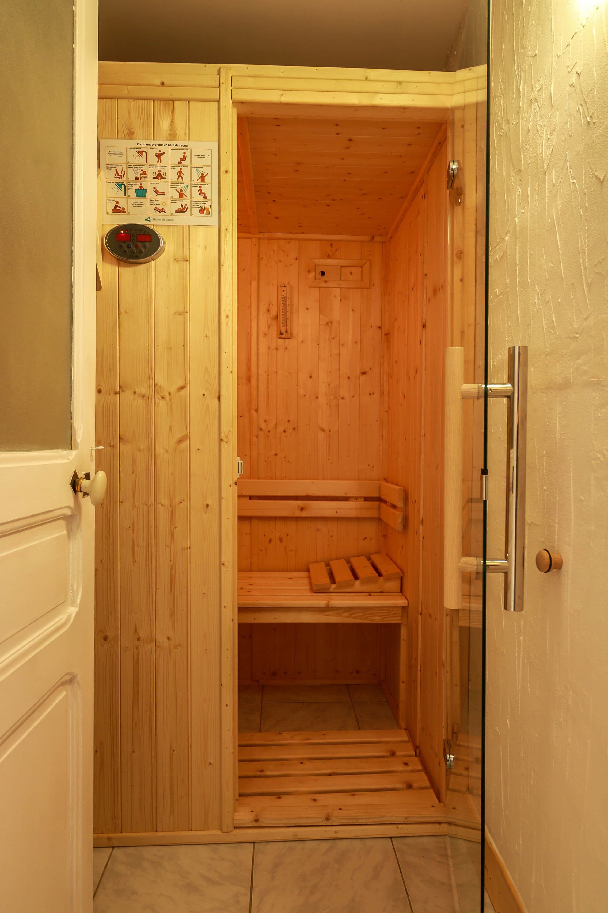 Un sauna avec des murs en bois et un banc.