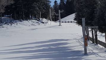 Pista da sci innevata con una recinzione in legno e un segnale.