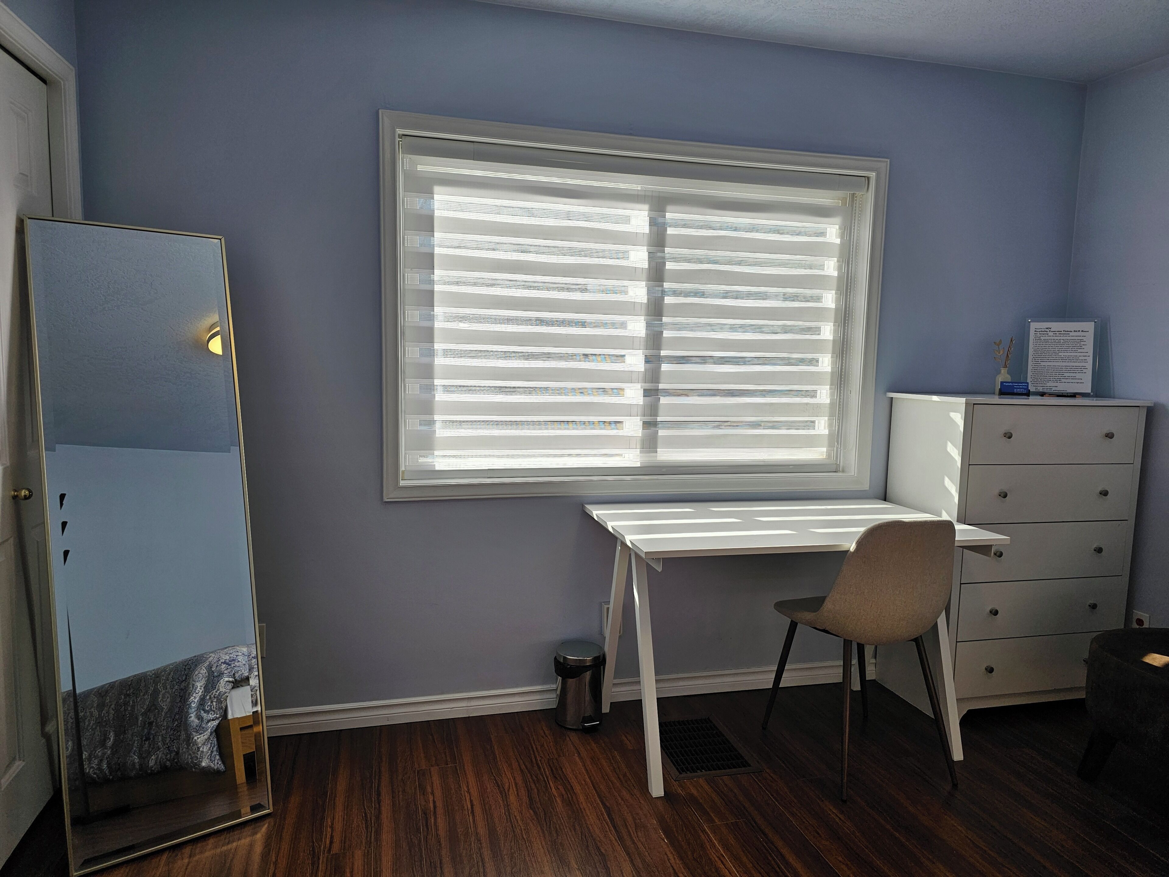 Une pièce comprenant un bureau, une chaise, une commode et un miroir.