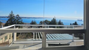 A view from a balcony overlooking a body of water with a distant city skyline. - HOV B&B House -Hospitality Ocean view Victoria- (Victoria)