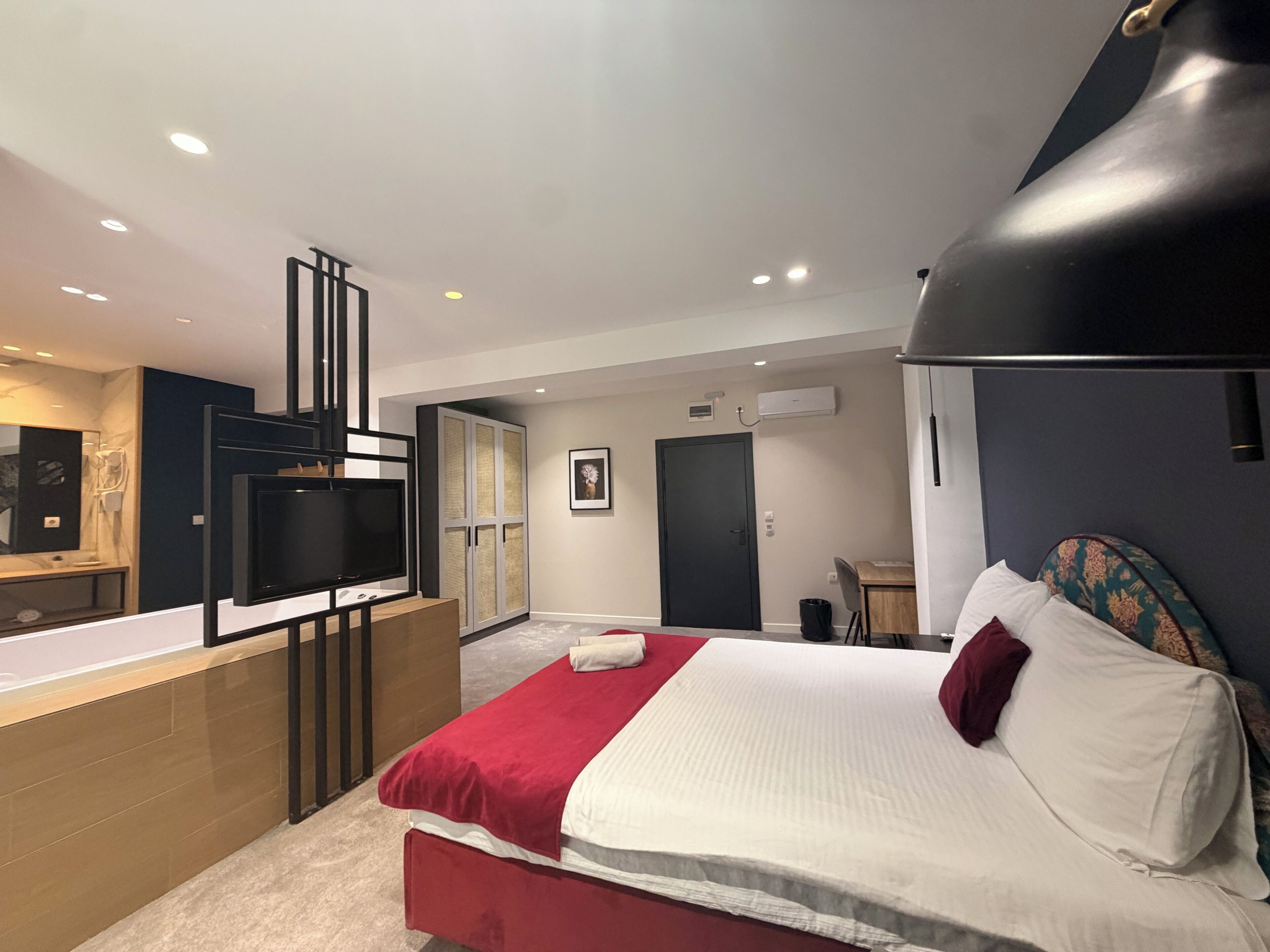 Une chambre d’hôtel moderne équipée d’un lit, d’une télévision, d’un bureau et d’une armoire.