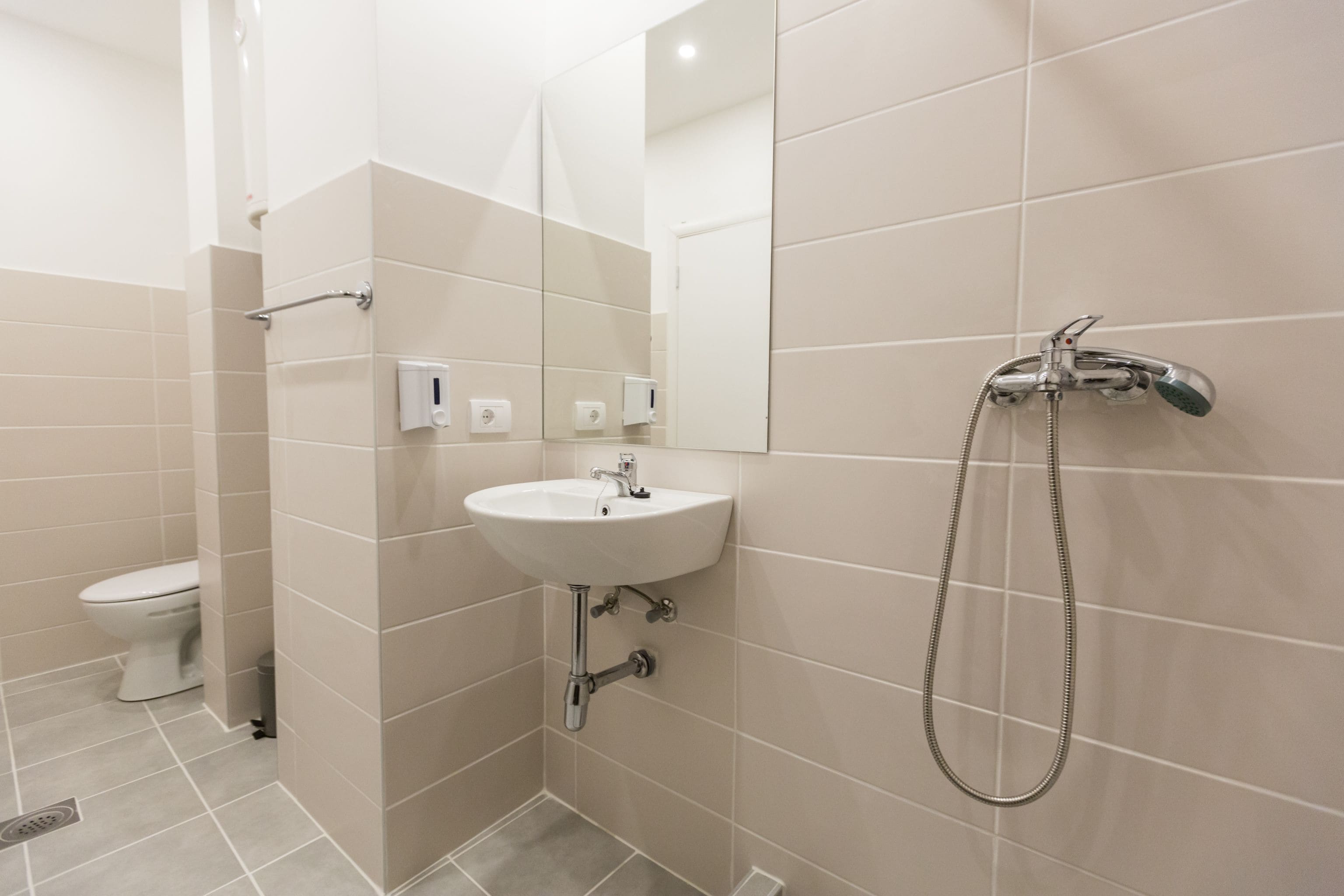 A bathroom with a sink, mirror, and shower.