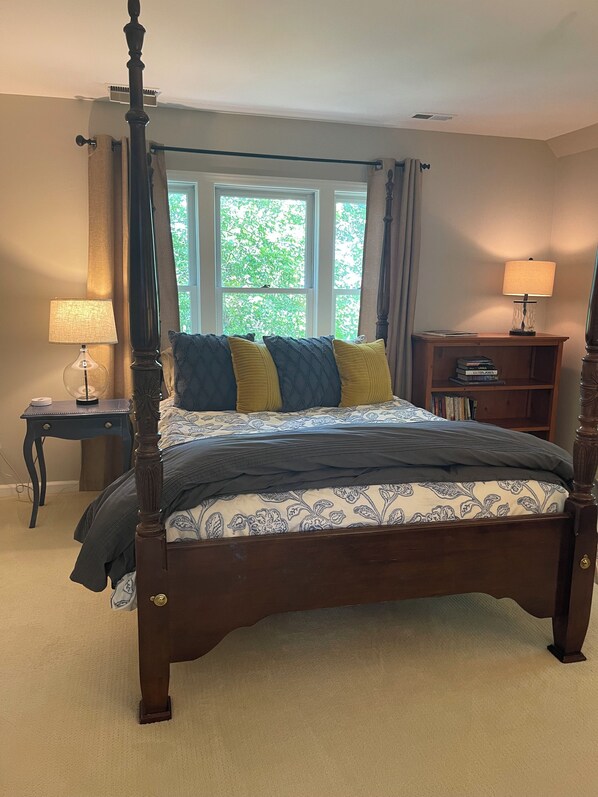 A four-poster bed with a dark finish, a bedside table with a lamp, and a window with curtains. - Central to Blowing Rock, App State, Tweetsie, Downtown Boone and Ski Mountains! (Boone)