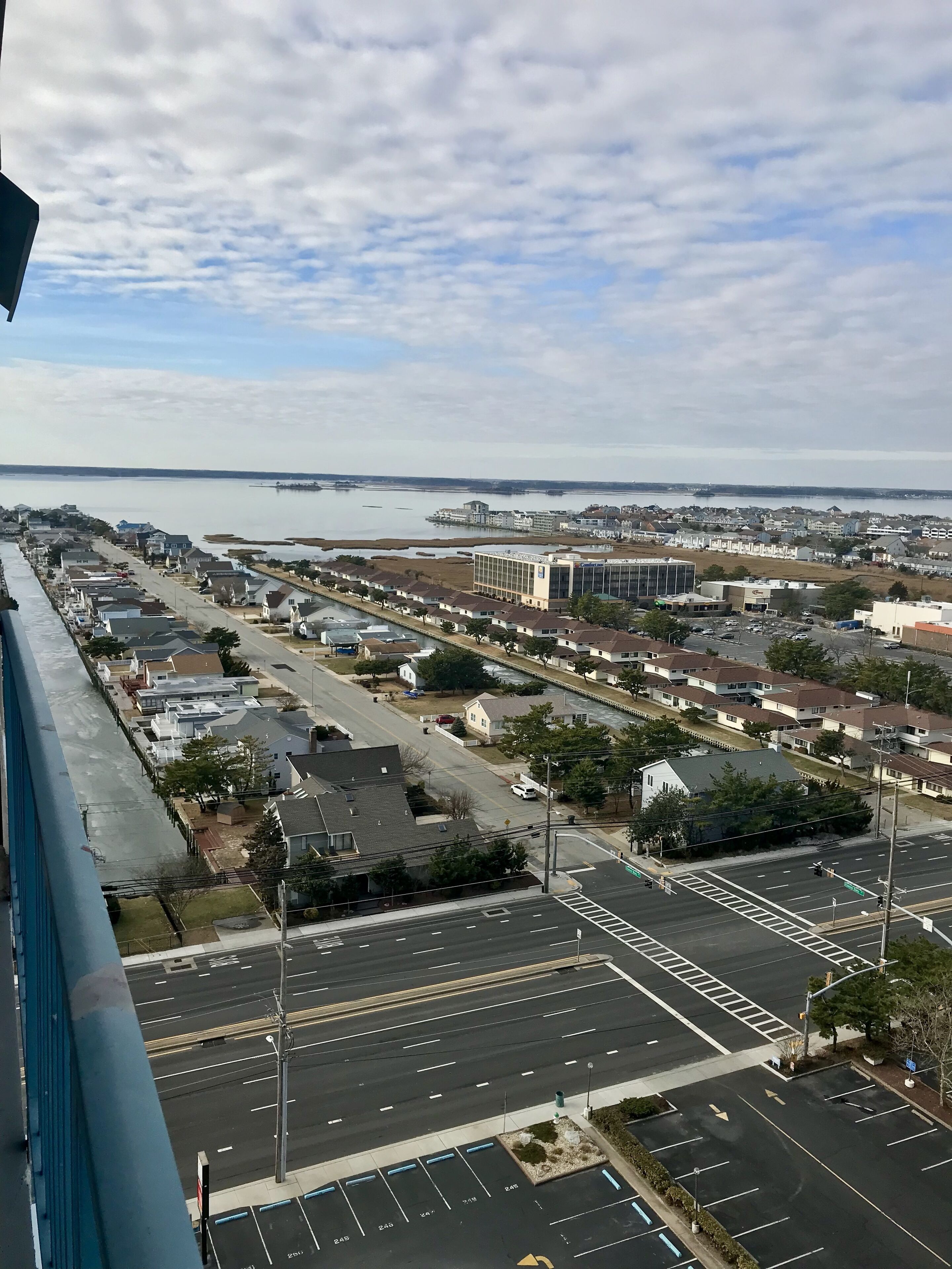 A coastal town with a marina, residential buildings, and a large commercial building.