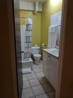 Ein kleines Badezimmer mit Toilette, Waschbecken und Duschvorhang.
