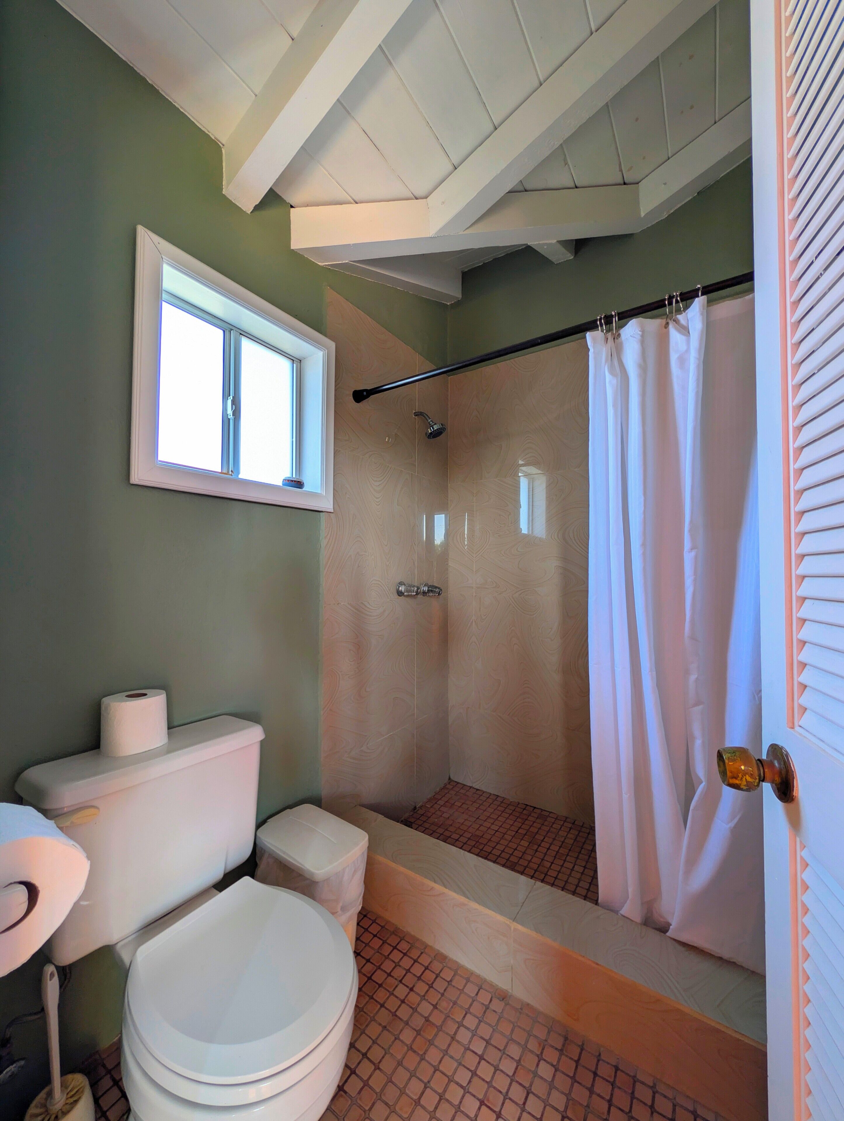 Une salle de bain avec une douche, des toilettes et un lavabo.