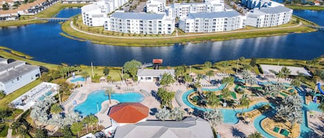 A resort with a central pool, a water park, and multiple apartment buildings.