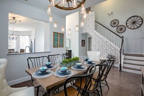 Enjoy meals with family and friends in this spacious dining area, featuring a beautifully set table with fine china and a stunning chandelier.