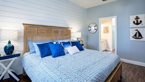 Un dormitorio con cama, cabecera de madera y decoración náutica.