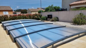 A large, flat, metallic structure with a transparent top, likely a sunroom or conservatory, installed on a tiled patio. - Stylish modern villa with private heated pool in scenic Trebes, near Carcassonne (Trèbes)