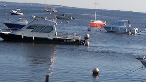 Un port de plaisance où sont amarrés différents types de bateaux, notamment un grand yacht et un voilier plus petit.