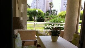 A balcony with a table, chairs, and a potted plant. - AIR CONDITIONING, FREE WIFI, NE TFLIX, ONLY 2 MINUTES BEACH (Alicante)