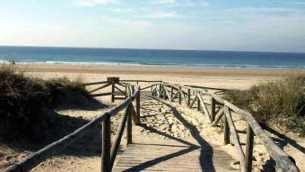 A wooden boardwalk leading to a sandy beach with the ocean in the background. - Villa with private pool in Pinar de los Franceses (WIFI) (Chiclana De La Frontera)