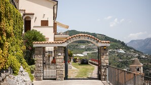 A villa entrance with a stone gate, a clear view of the surrounding hills, and a pathway leading to the villa. - Apt Emma in Villa Laura near Ravello (scala)