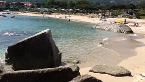 A beach with large rocks in the foreground, clear water, and a mountain in the background. - Apartment/ flat - LUMIO (Lumio)