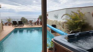 A swimming pool with a hot tub, surrounded by chairs and potted plants. - Casa Valderrama - Beautiful Spacious Villa With Private Pool And Hot Tub.  (La Herradura)
