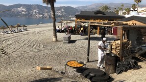 A beachside restaurant with outdoor seating, a grill, and a view of the sea and mountains. - Casa Valderrama - Beautiful Spacious Villa With Private Pool And Hot Tub.  (La Herradura)