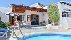 A poolside area with a clear blue pool, lounge chairs, and a pergola. - Villa with private pool and free wifi (Tías)