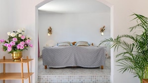 A bedroom with a bed, a small table with a vase of flowers, and a potted plant. - Villa with private pool and free wifi (Tías)