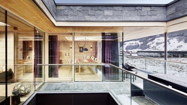 Ein modernes Interieur mit Essbereich, großen Fenstern und Blick auf eine verschneite Landschaft.