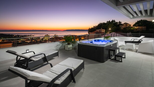A rooftop terrace with outdoor seating, a hot tub, and a view of the sunset over the sea. - Luxury villa Palladium in the center with * heated pool, * penthouse and * whirlp. (Makarska)