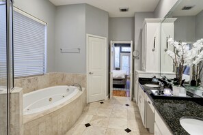 Een bad/douchecombinatie, een haardroger, handdoeken, zeep