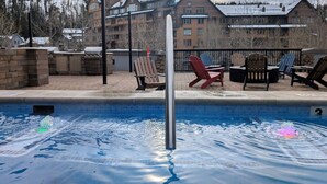A pool with a metal pole in the center, surrounded by lounge chairs and a brick patio. - Front Corner at Base: 3 King Beds, Deck, Views (Winter Park)