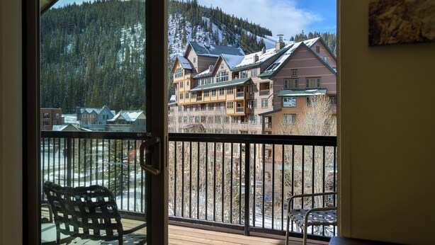 A balcony with a view of a mountain and buildings. - Front Corner at Base: 3 King Beds, Deck, Views (Winter Park)