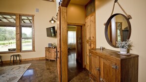 Une pièce spacieuse avec une grande armoire en bois, un miroir et un téléviseur fixé au mur.