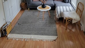 A cozy living room with a grey sofa, a round side table, a patterned rug, and a wooden floor. - ** Close to Sight and Sound Theater<br>Mother's day weekend available  (Ronks)