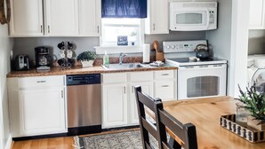 A kitchen with white cabinets, a microwave, a stove, a dishwasher, and a dining table with chairs. - ** Close to Sight and Sound Theater<br>Mother's day weekend available  (Ronks)