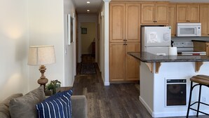 A modern kitchen with wooden cabinets, a built-in microwave, and a refrigerator. - 2 BR on Jersey Ct Just Steps to The Beach (San Diego)