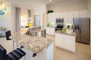Enjoy cooking in this well-equipped kitchen with a central island, sink, and stainless steel appliances.