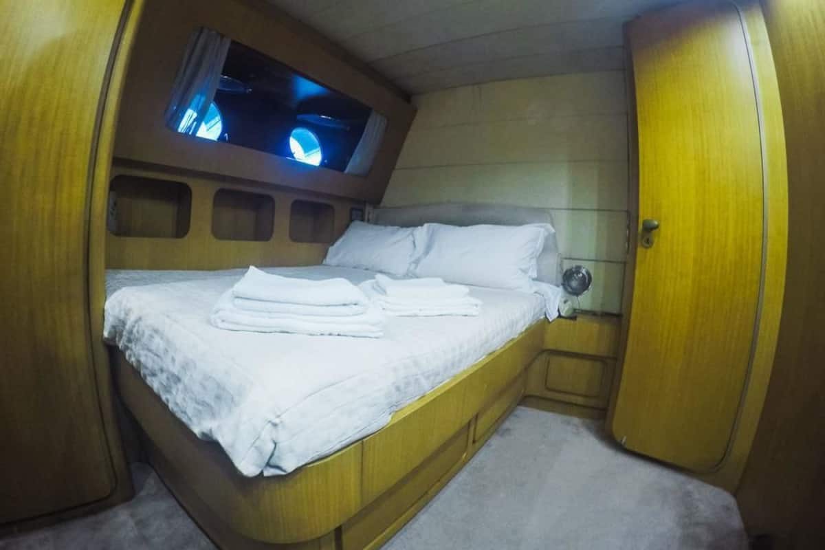 A compact, well-lit cabin with a bed, a small window, and a door.