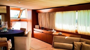 A cozy interior with a dining area, a sofa, and a coffee table. - Yacht Diva (Venice)