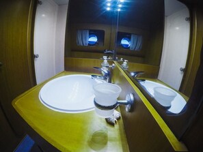 A bathroom with a large mirror, two sinks, and a yellow countertop. - Yacht Diva (Venice)